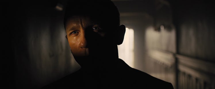 Daniel Craig's James Bond stands in a dimly lit hallway in Skyfall