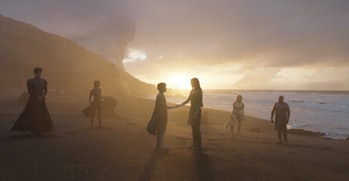 The Eternals stand together on the beach at sunset