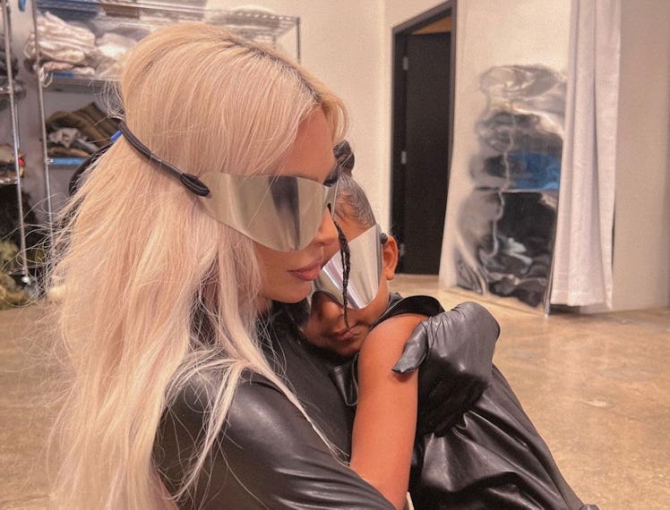 Kim holding her daughter wearing matching outfits
