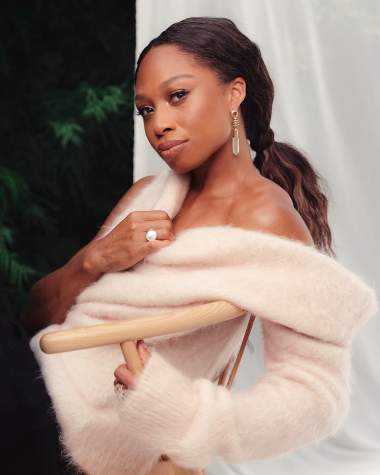 Allyson Felix wearing a peach colored SportMax sweater while posing in a garden