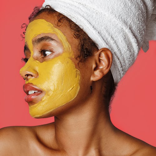 A lady with a yellow glow-boosting turmeric mask on her face