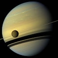 titan crosses saturn with the rings seen edge-on