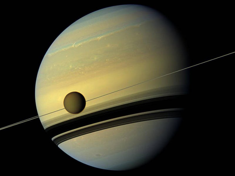 titan crosses saturn with the rings seen edge-on