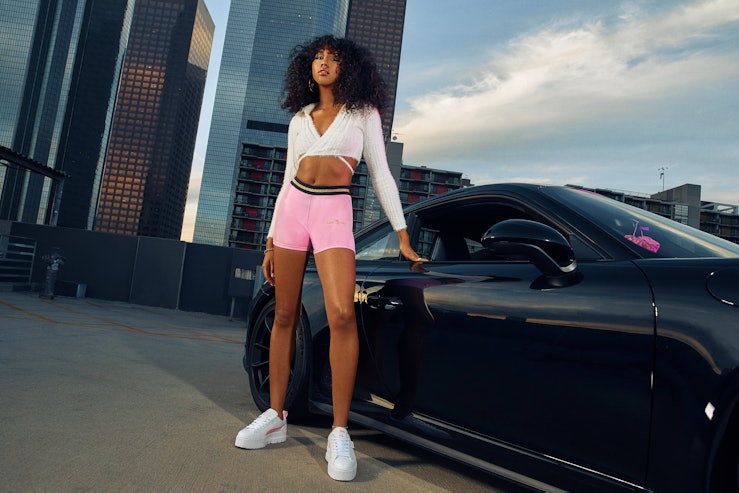 A model for Puma and Baby Phat in pink shorts and a white cropped long-sleeved shirt