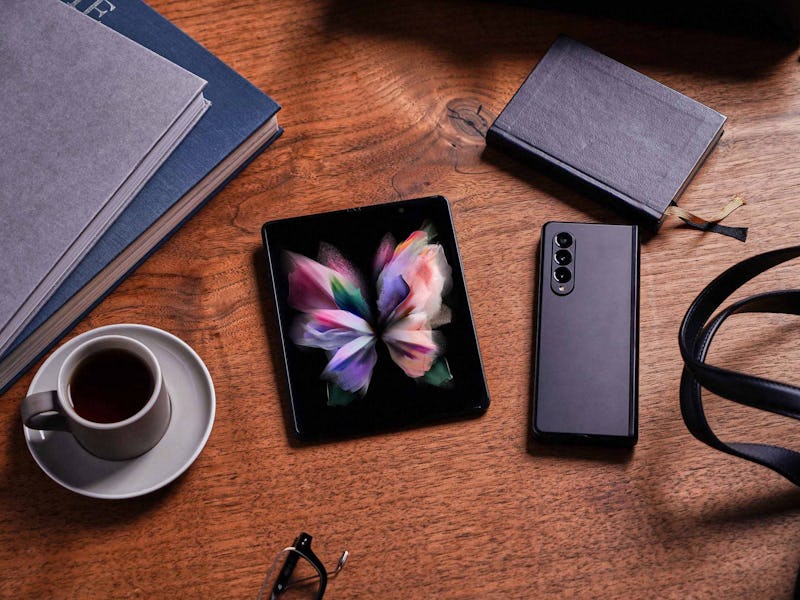 Samsung Galaxy Z Fold 3 pictured on a desk with other devices