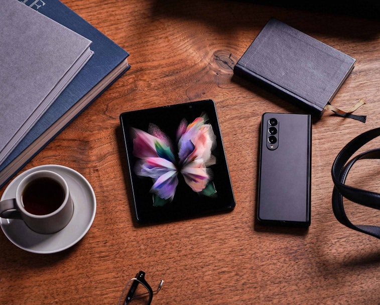 Samsung Galaxy Z Fold 3 pictured on a desk with other devices