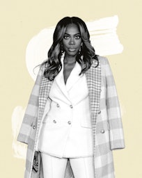 Actor & Comedian Yvonne Orji wearing a white suit and a pink checked coat over her shoulders