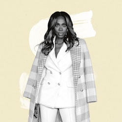 Actor & Comedian Yvonne Orji wearing a white suit and a pink checked coat over her shoulders