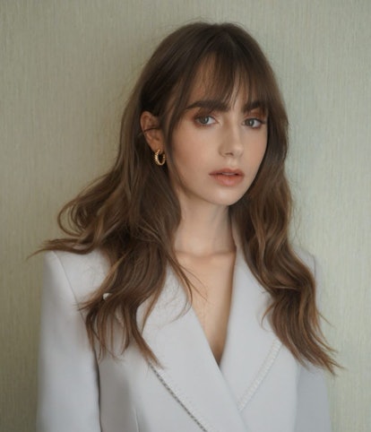 Lily Collins showcases smoked chestnut strands, one of fall 2022's hair color trends to watch.