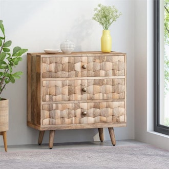 This mid-century style dresser for small spaces has a textured, wooden look and three drawers.
