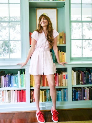 Gray is leaning against a book shelf. She is wearing a striped dress and red Suede Classic Sneakers ...
