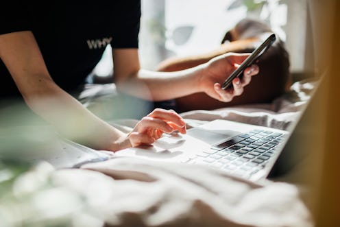 Stock image of person using a laptop and a smart phone