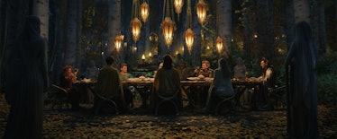 A group of elves and dwarves sit around a banquet table together in The Lord of the Rings: The Rings...