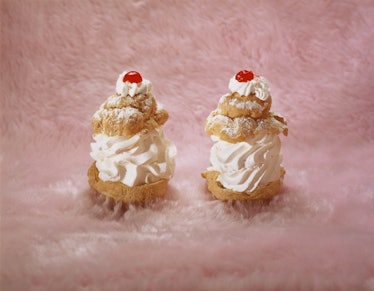 Two cherry-topped pastries on a swath of pastel pink fur