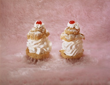 Two cherry-topped pastries on a swath of pastel pink fur
