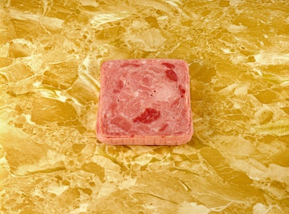 A Sandy Skoglund photo of a slab of luncheon meat on a gold counter