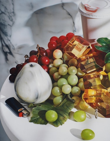 A Roe Ethridge still life of fruit featuring a marble pear and a lighter