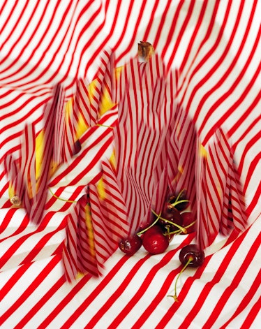 A Lucas Blalock image featuring cherries on a swath of red-and-white striped fabric