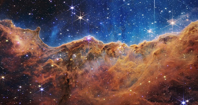 The image is divided horizontally by an undulating line between a cloudscape forming a nebula along ...