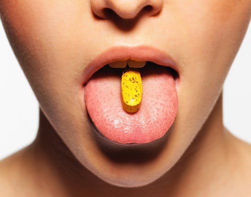 woman with a pill on her tongue