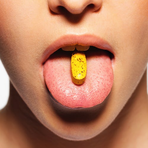 woman with a pill on her tongue
