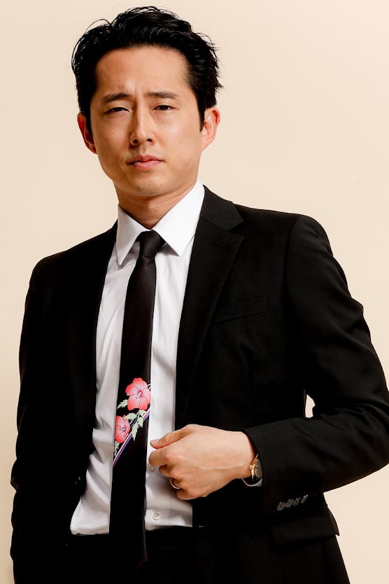 Steven Yeun posing in a floral necktie 