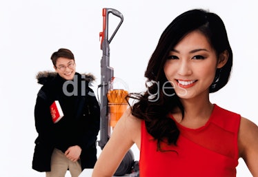 A faux stock photo of a Dyson vacuum between two people smiling 