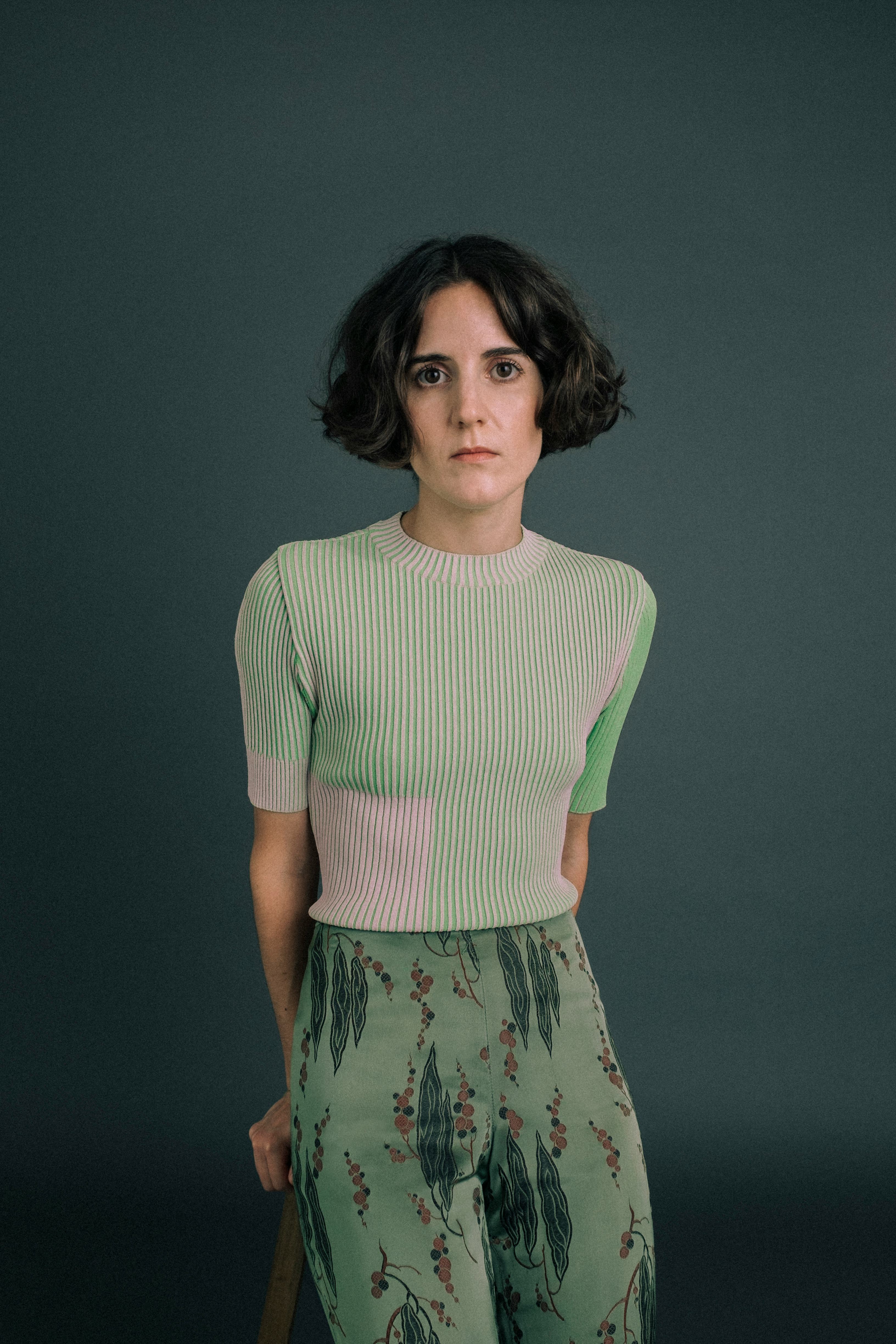 A portrait of Ana Fabrega wearing a green knit shortsleeve sweater