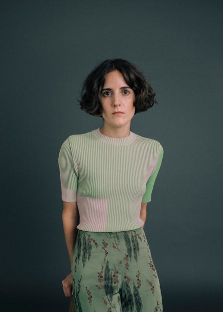 A portrait of Ana Fabrega wearing a green knit shortsleeve sweater