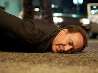 Nicolas Cage lying on concrete ground in "Stolen" movie 
