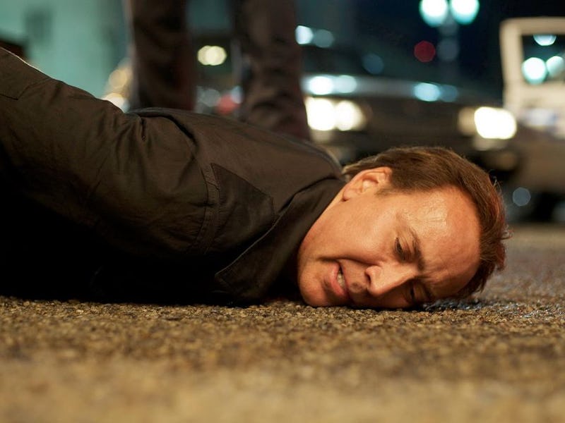 Nicolas Cage lying on concrete ground in "Stolen" movie