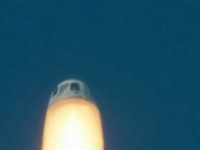 a capsule with large flames beneath it