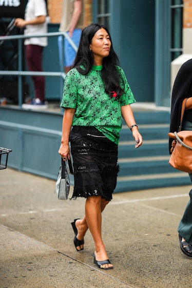 A guest wears a black and green print pattern t-shirt, a black ruffled / fringed tulle knees skirt, ...
