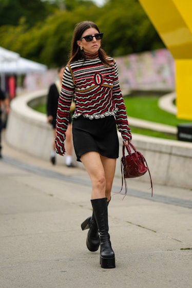 A guest wears black sunglasses, a red / white / black striped print pattern long sleeves / turtlenec...
