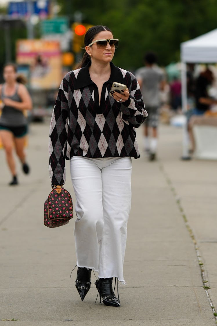 A guest wearing a wool polo oversized shirt, large white jeans and a brown LV monogram print bag fro...
