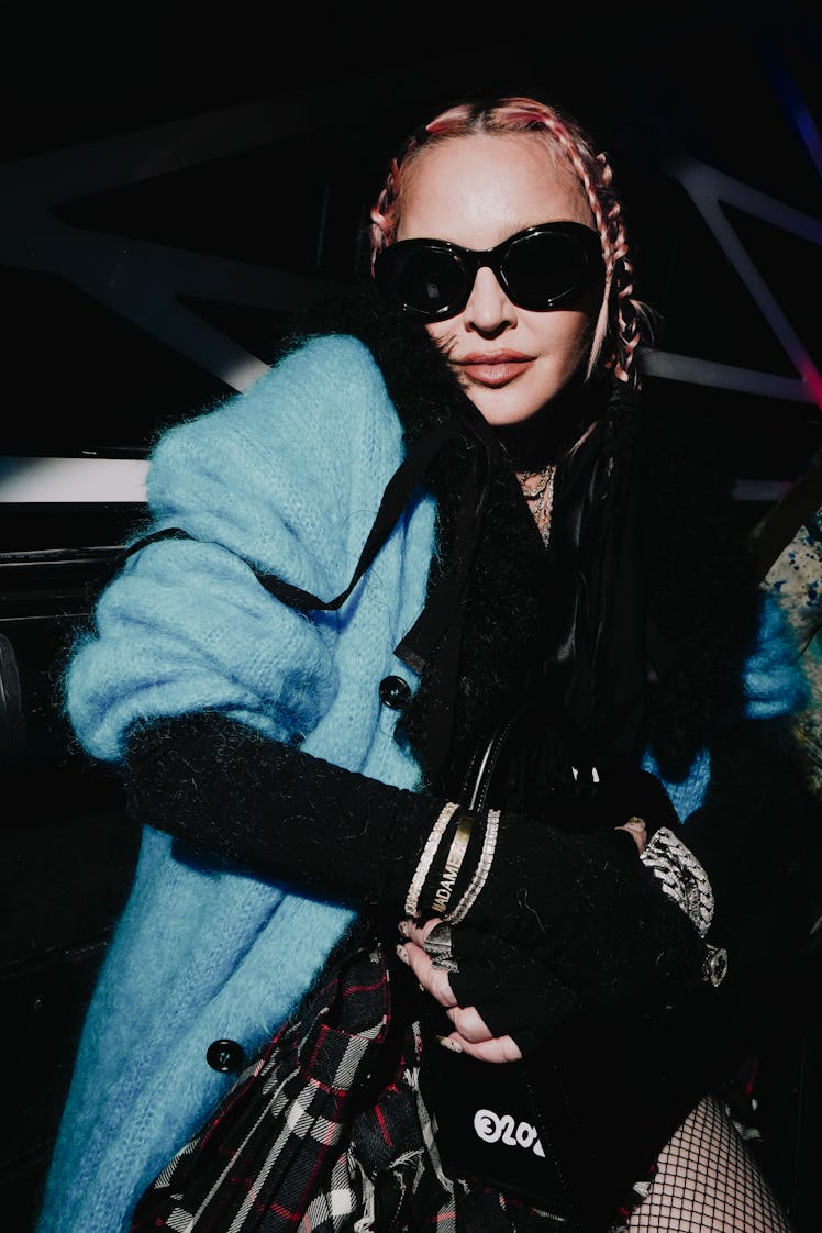 Madonna walking in a blue coat