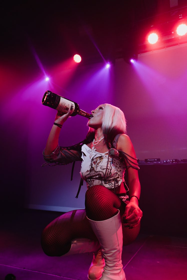 Doja Cat drinking champagne onstage during her performance