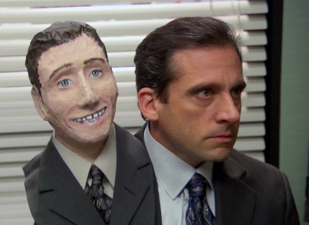Michael Scott with a papier-mâché version of his own head on his shoulder.