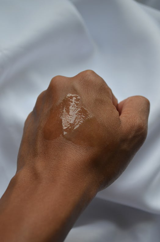 A photo of the Omorovicza Even Tone Serum on the back of a hand.