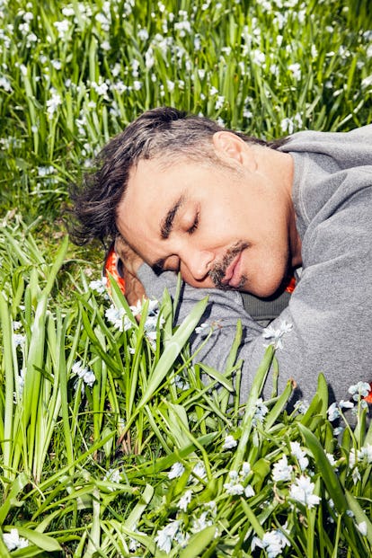 David LaChapelle resting his head on a bed of grass