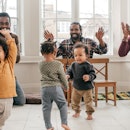 Three parents and their toddlers dancing during a playdate.