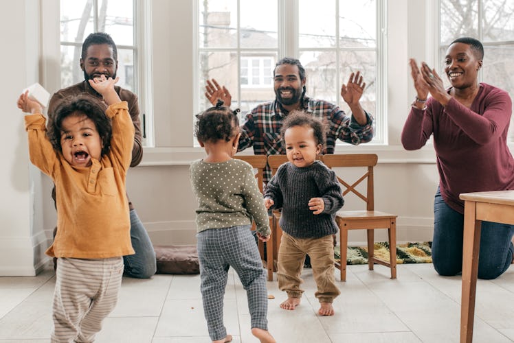 Three parents and their toddlers dancing during a playdate.