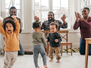 Three parents and their toddlers dancing during a playdate.