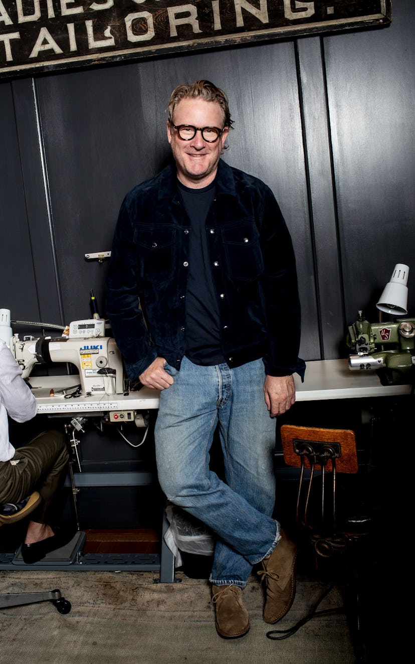 8235767f 7c79 4902 aa99 f674a984043e 4 Todd Snyder leaning on a desk with a sewing machine.