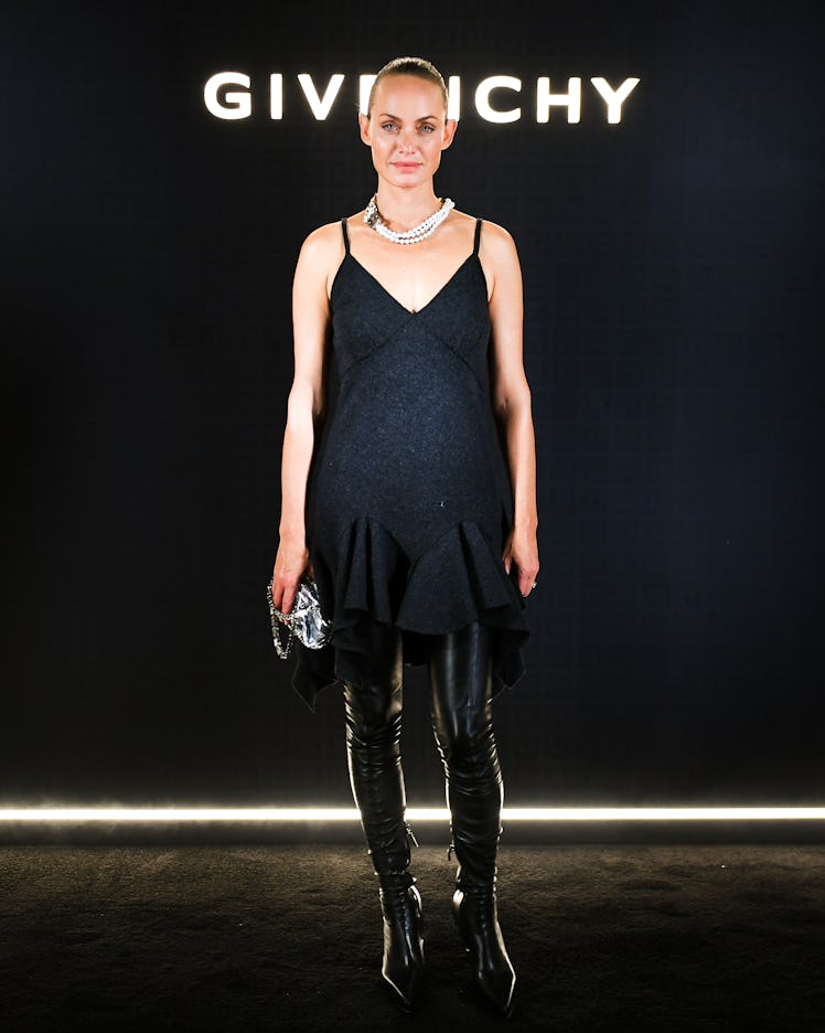 Amber Valletta posing in a black dress