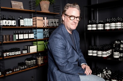 Todd Snyder sitting in front of shelves with menswear beauty products which emulate everything right...