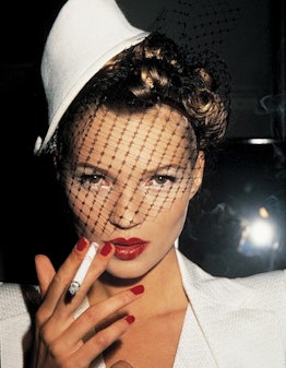 Kate Moss wearing a veil and smoking a cigarette