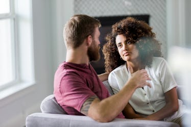 Man and woman sitting on couch having serious discussion