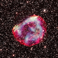 Glowing pink, green, and blue dust clouds make up a supernova remnant against a backdrop of bright s...