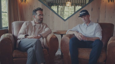 Ryan Reynolds and Rob McElhenney sit on a couch talking about their coloscopies. 